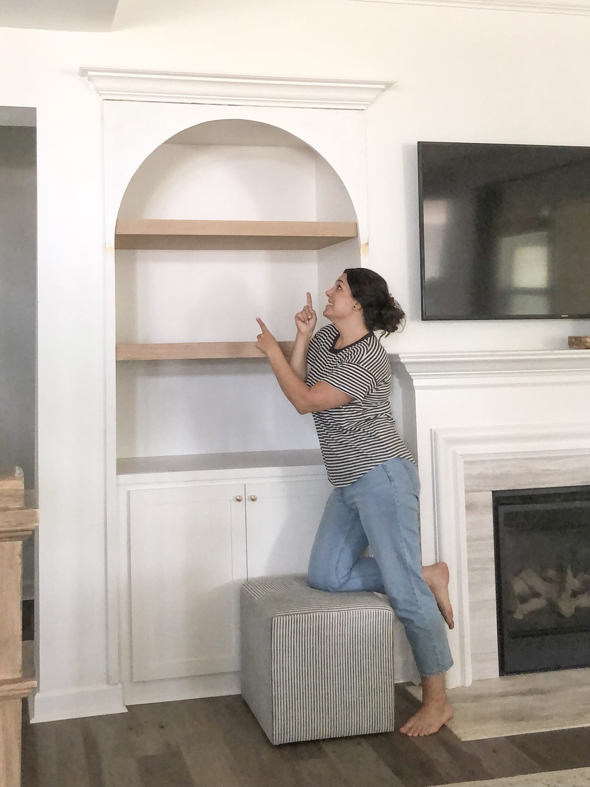 girl with arched built ins and oak floating shelves