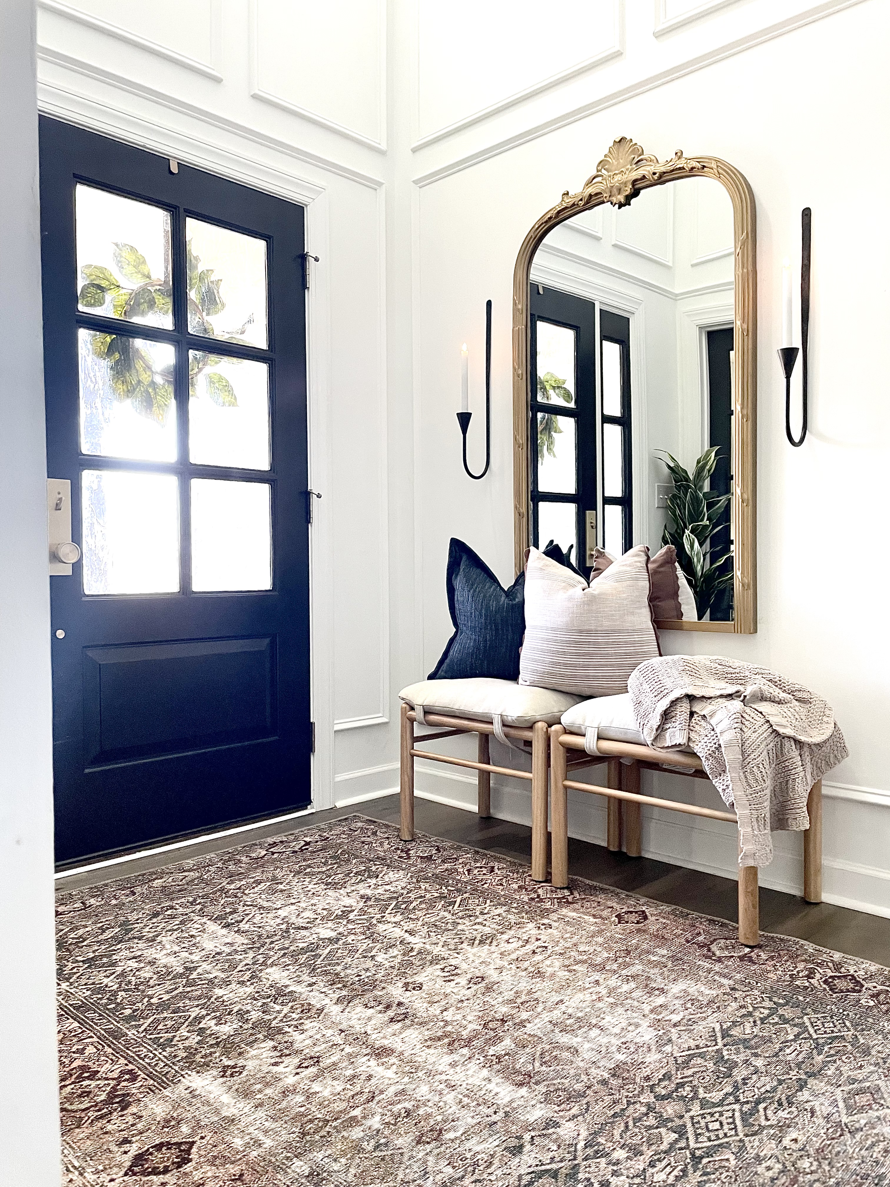 bench with pillows and blankets and gold mirror and black candlesticks all encased by picture frame molding