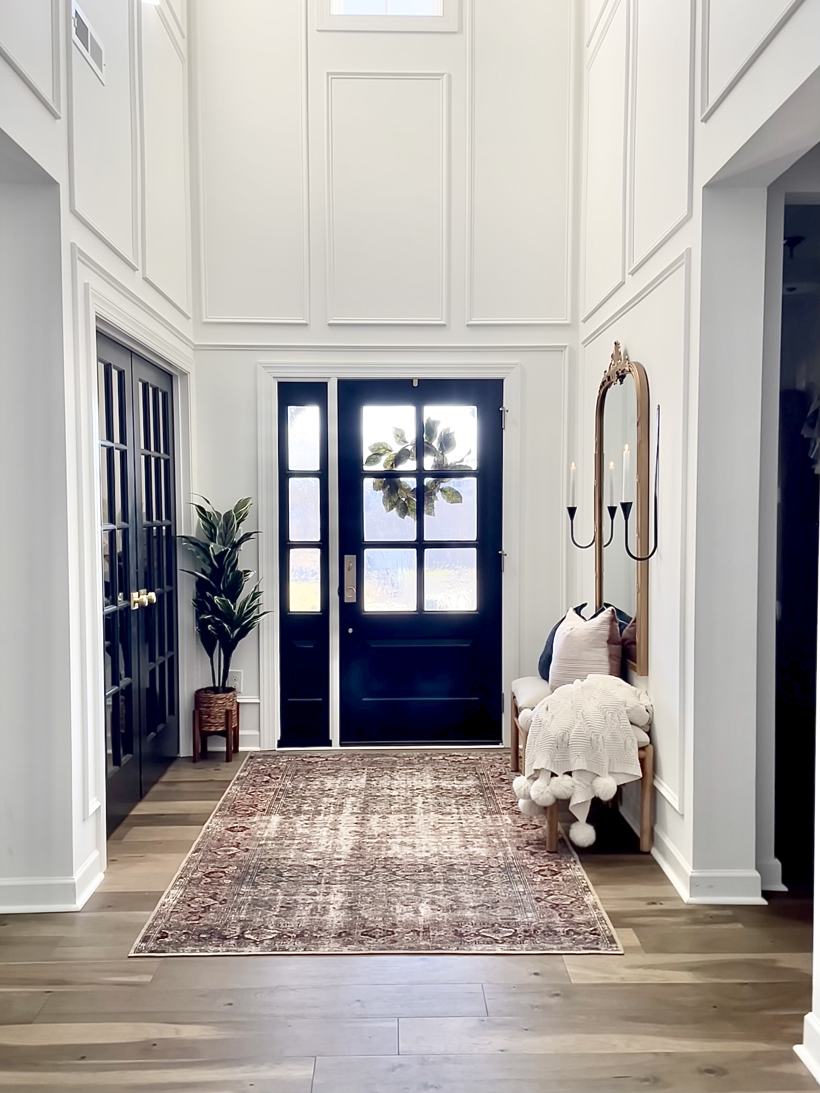 entryway with white walls and picture frame moulding