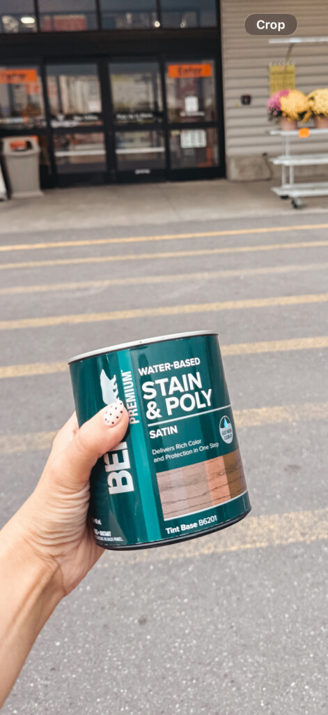 woman diyer holding behr stain and poly outside of the home depot