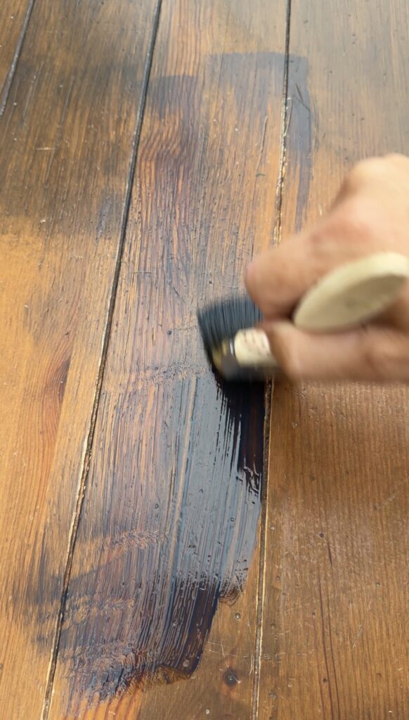 table being stained with a paintbrush